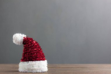 Seçici odak güzel kırmızı Santa Cluas ve Noel şapka. Dekorasyon kış sezonu ve neşeli Noel ve mutlu yeni yıl kavramı arka plan. Modern rustik Brown'un bulanıklık gri ile ahşap temel öğeleri.