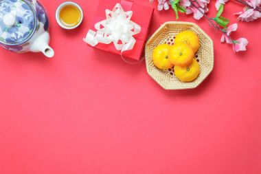 Tablo üstten görünüm görüntü bir kadeh dekorasyon Çin yeni yıl ve ay tatil arka plan kavramı. Turuncu ve çaydanlık da kırmızı hediye kutusu ile süsler. Çeşitli modern zemin üzerinde ev ofis büro nesneleri..
