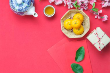 Üstten Görünüm resim görüntüsünü düzenleme dekorasyon Çin yeni yıl ve ay tatil arka plan kavramı. Turuncu ahşap sepet ve çaydanlık süslemeli Ev Ofis Masası, modern kırmızı duvar kağıdı şenlikli.
