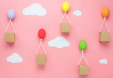 Üstten Görünüm düzenleme dekorasyon mutlu Paskalya tatili arka plan kavramı bir kadeh. Düz renkli Paskalya yortusu yumurta balon uçan transfer bulut office desk.pastel sesi ile hediye kutusu gökyüzü pembe kağıt üzerinde göklere.