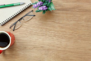 Tablo üstten görünüm havadan görüntü ofis Resepsiyon arka plan kavramı üzerinde sabit. Düz nesneleri temel aksesuarıyla kahve fincan yatıyordu. Modern kahverengi ahşap ev stüdyosunda öğeleri. İçin alan metin eklemek.