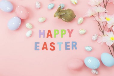 Tablo üstten görünüm düzenleme dekorasyon mutlu Paskalya tatili arka plan kavramı bir kadeh. Çiçek ve tavşan ile düz yatıyordu renkli tavşan yumurta evde pembe kağıt üzerinde Ofis Masası ile metin sezon bebek..