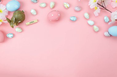 Tablo üstten görünüm düzenleme dekorasyon mutlu Paskalya tatili arka plan kavramı bir kadeh. Düz renkli bunny alanı ile ev ofis Masası, modern rustik pembe kağıt üzerinde çiçek ve tavşan bebek ile yumurta