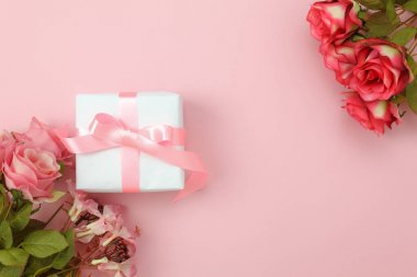 Üstten Görünüm dekorasyon mutlu anneler günü tatil arka plan kavramı hava görüntüsü. Düz çocuk ayakkabı ve çocuk oyuncak ev ofis Masası, pembe kağıt üzerinde pembe Gül işareti sezon yatırın.