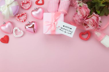 Tablo üstten görünüm dekorasyon mutlu anneler günü tatil arka plan kavramı hava görüntüsü. Düz yatıyordu tebrik kartı hediye kutusu ve güzel modern pembe kağıt üzerinde temel nesneleri ile gül çiçek. Pastel tonu.