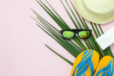 Yaz tatil arka plan kavramı seyahat öğelerin tablo üstten görünüm havadan görüntü. Sahil gezi seyahat için düz yatıyordu gerekli aksesuarlar. Moda terlik ve yeşil Hindistan cevizi yaprağı şapka ile güneş gözlüğü.
