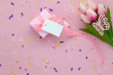 Düz yatıyordu havadan görüntü öğeleri anneler günü tatil arka plan kavramının. Rustik pembe kağıt modern zemin kopya alanı ile kelebek ile tablo üstten görünüm hediye kutusu ve Lale çiçek. Pastel tonlu tasarım.