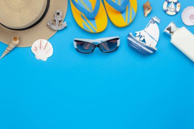 Tablo üstten görünüm yaz ve seyahat plaj tatil sezonu arka plan kavramı içinde hava görüntüsü. Düz yatıyordu gerekli aksesuarları seyahat için. Beyaz losyon ve mavi kağıt ve kopya alanı giyim kadın.