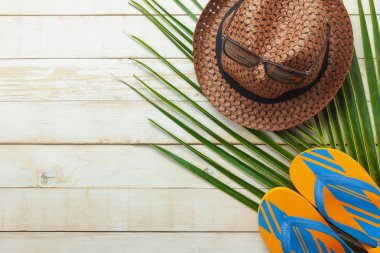 Yaz tatil arka plan kavramı seyahat öğelerin tablo üstten görünüm havadan görüntü. Sahil gezi seyahat için düz yatıyordu gerekli aksesuarlar. Moda terlik ve yeşil Hindistan cevizi yaprağı şapka ile güneş gözlüğü.