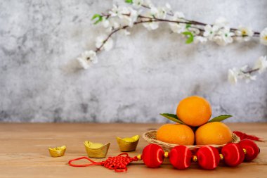 Ay Yeni Yılı Aksesuarları & Çin Yeni Yıl Tatil Konsepti arka planında. Altın para ve kırmızı erik çiçekleri ile ahşap septte portakal rengi ve kahverengi & gri taş fon üzerinde beyaz erik çiçeği.