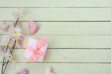 Uluslararası Kadınlar Günü tatili konsepti için gökyüzü resmi. Düz pembe çiçek ve modern kırsal beyaz ahşap üzerine hediye kutusu ile temel aşk sezonu yatıyordu..