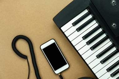 Müzik enstrümanı araçları kavramının en üst görünümü arka plan. Müzisyen veya parti ekipmanları için şarkı söylemek için tabela düzlüğü. Cep telefonu ve elektronik piyano modern gri çimentoda. Yaratıcı tasarım için alan.