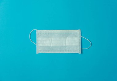 Aksesuarların hava görüntüsü ve tıbbi geçmiş konsepti. Mavi kağıt üzerindeki temel araçlar veya ekipman araçları maskesi. Viral Covid-19 'u korumak için düz konum