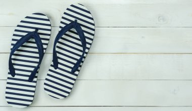 Yaz tatili arka plan kavramında seyahat için aksesuarların en üst görünümü. Modern rustik beyaz ahşap üzerinde mavi terliklerin düz uzantısı. Yaratıcı tasarım metni ve kelime oluşturma için kopyalama alanı.