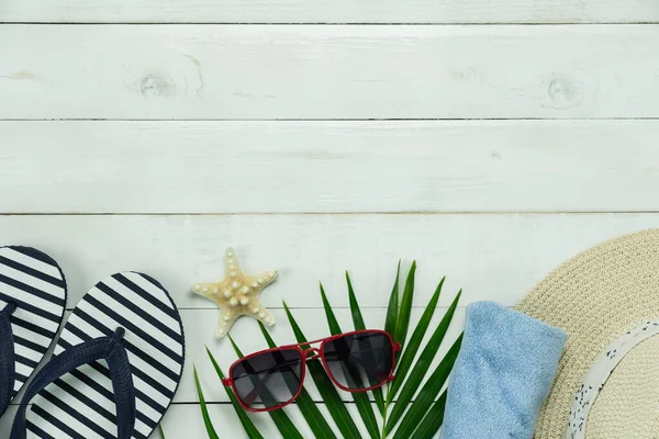 stock image Table top view aerial image of women fashion to travel in beach summer holiday background.Flat lay essential accessories red sunglasses & sandals with hat and napkin objects lay on white wooden.