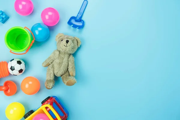 Masa üstü dekorasyon çocuk oyuncakları arka plan kavramını geliştirmek için. Bebek bezi, ofis masasındaki modern mavi kağıt üzerinde çocuklarla oynamaları için kullanılacak. Metin eklemek için alanı kopyalayın..