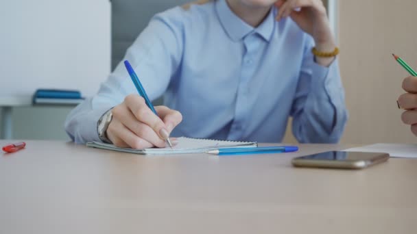 Pravá ruka vedoucího mladých žen je psaní poznámek během konzultace s šéfem.