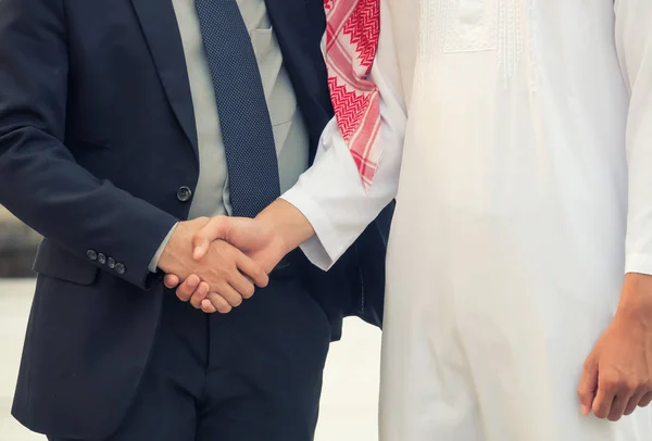 Businessman and Business Arabian man hands shaking