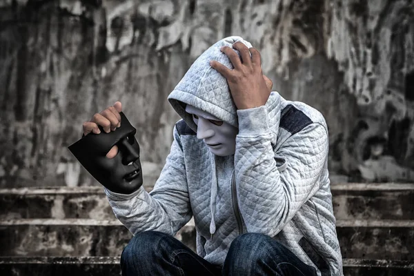 Man in the hood and white mask with confused depression — Stock Photo, Image