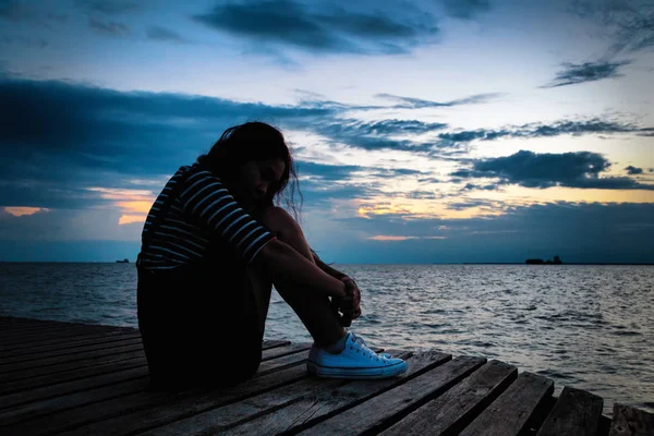 Donna in depressione frustrata seduta su un ponte di legno — Foto Stock