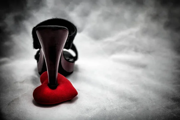 Жіноче взуття на зламаному серці в темному тоні., нерозділене кохання, концепція любові до дня валентинки . — стокове фото