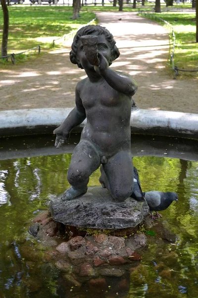 聖ニコラス大聖堂の近くの噴水の つのペアのいずれか 裸の少年を緑豊かな公園 サンクトペテルブルクの噴水のボウルの中央に角の彫刻 — ストック写真