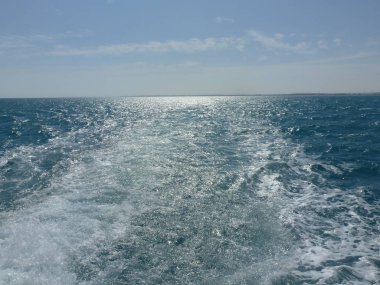 Denizlerin mavi enkazında yattan köpüklü izler.