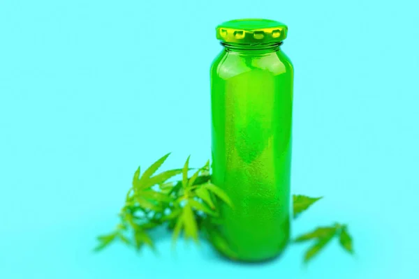 Smoothie CBD Cannabis em garrafa de suco de vidro verde isolado em azul, conceito de maconha medicinal — Fotografia de Stock