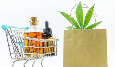 Marihuana yaprakları ve tıbbi kenevir yağı ile süpermarket arabası