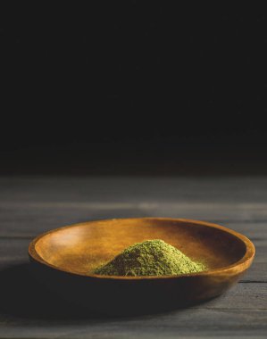 Mitragynina Specosa ya da Kratom tozu ahşap kasede masanın üstünde