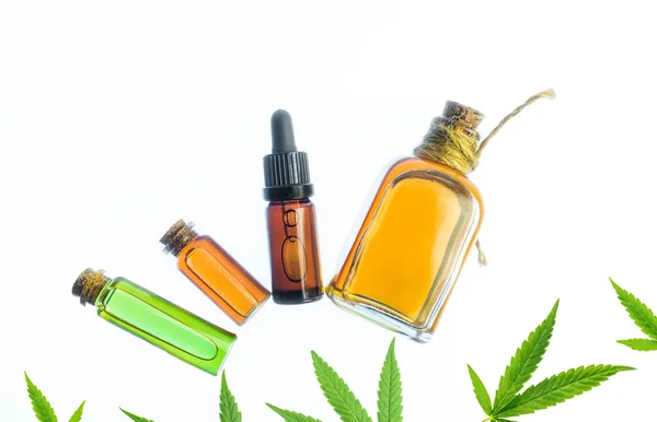 Glazen flessen met Cannabis Cbd olie en Thc tinctuur en hennepbladeren op witte achtergrond — Stockfoto