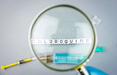 Sars CoV 2 Covid 19 Magnifying glass on alphabet dices with the word Chloroquine a possible treatment for Corona Virus clipart