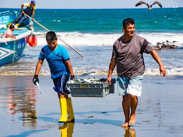 Fischer tragen Fischkörbe zu den Käufern, gejagt von Vögeln, die nach — Stockfoto