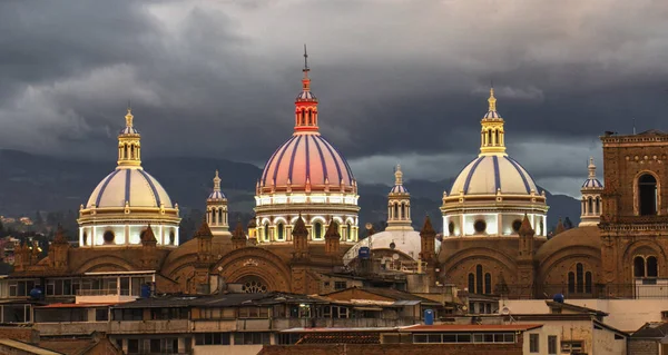 Nové dómy katedrály v Cuenca, Ekvádor jsou osvětleny v barvách městské vlajky pro Den nezávislosti, zobrazeno za soumraku — Stock fotografie