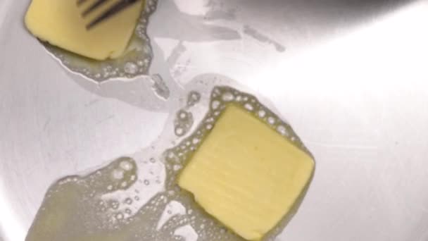 Butter melting in steel frying pan from overhead view — Stock Video