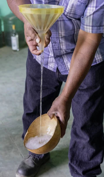 Mezcal se vierte a través de un embudo para estudiar las burbujas y determinar el nivel de alcohol en la bebida —  Fotos de Stock