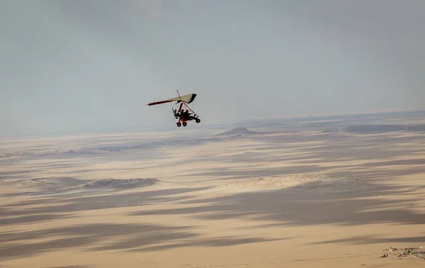 Walvis Bay, Namibia - 16 de julio de 2018: Se ve un avión ultraligero volando con dunas de arena como telón de fondo —  Fotos de Stock