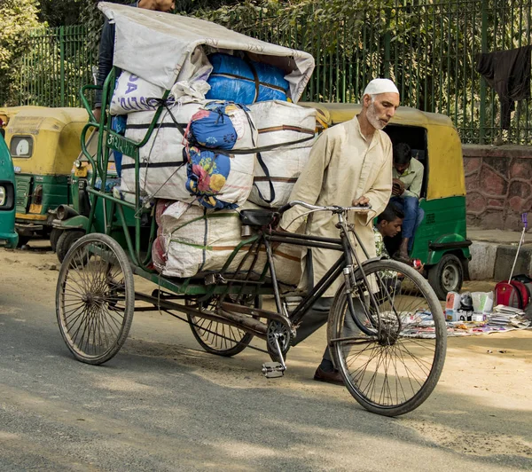 New Dehli, India, 19 de febrero de 2018: Hombre llevando carga masiva en bicicleta —  Fotos de Stock