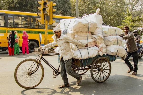 Нью-Дели, Индия, 19 февраля 2018 года: Человек несет огромный груз на велосипеде — стоковое фото