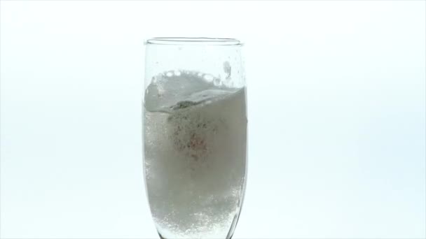 Champagne Glass Closeup - two strawberries dropped in full glass — Stock Video