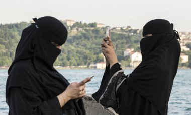 Ortakoy, Türkiye - 30 Mayıs 2016 - tesettürlü kadın telefonuna bakıyor