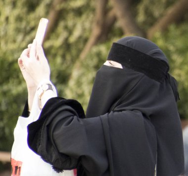 Ortakoy, Türkiye - 30 Mayıs 2016 - tesettürlü kadın telefonuna bakıyor