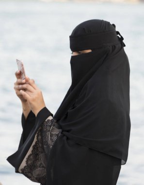 Ortakoy, Türkiye - 30 Mayıs 2016 - tesettürlü kadın telefonuna bakıyor