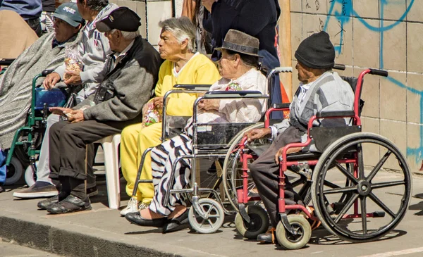 Tekerlekli sandalyeli insanlar Noel arifesinde geçit törenini izliyor.