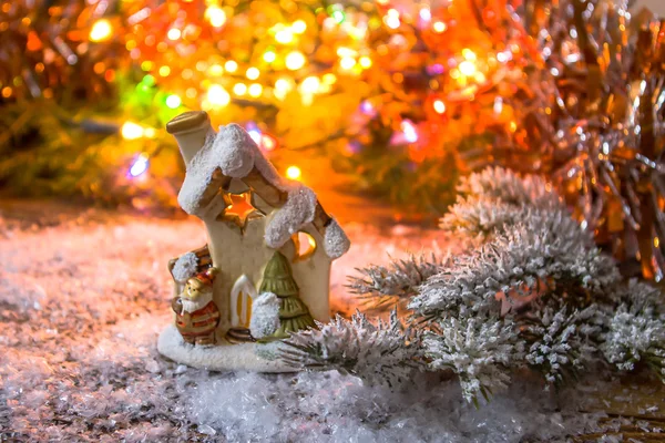 Xmas dekoration i snön på en bakgrund av suddiga ljuset och fir grenar med snö. — Stockfoto