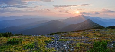 Dağlarda, panoramik manzaralı güzel bir gün batımı. Yaz yarış