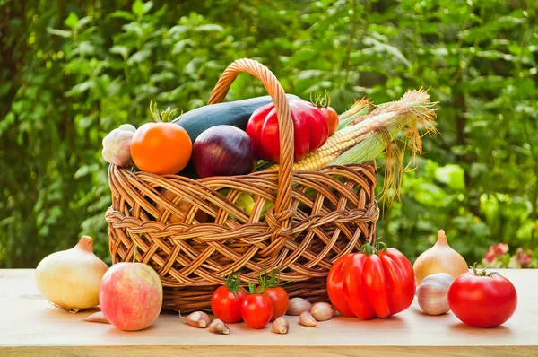 Tomatoes, onions and other vegetables in a wicker basket on a wo — Stock Photo, Image