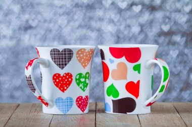 Kalp kalp şeklinde bokeh arka plan üzerinde iki bardak