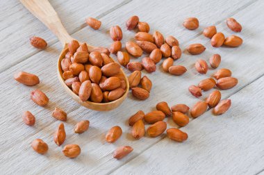 Tahta bir kaşıkta, tahta bir masada yer fıstığı.