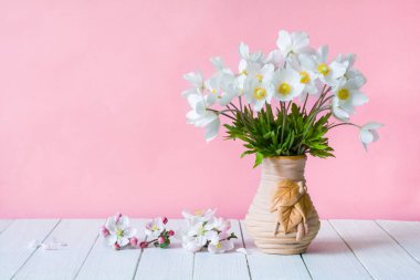 Pembe arka planda vazoda bir buket kır çiçeği. Anemone Sylvestri